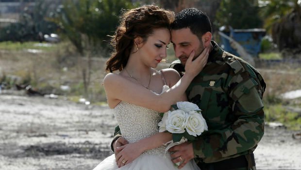 عروسان يحتفيان بدخولهما القفص الذهبي وسط دمار الحرب في حمص السورية + صور