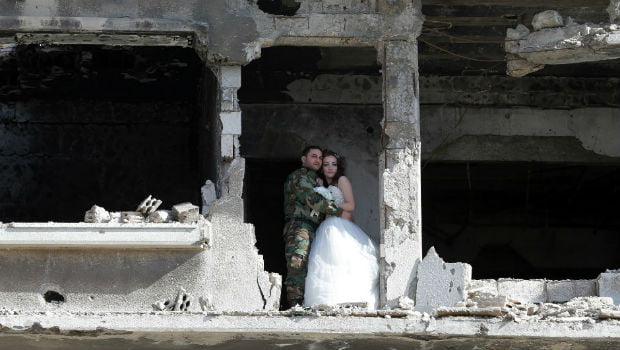 عروسان يحتفيان بدخولهما القفص الذهبي وسط دمار الحرب في حمص السورية + صور